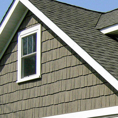 Sage green shake siding with cottage window grids trimmed in white.